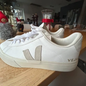 Vita sneakers från Veja - Snygga vita sneakers från Veja med klassisk design och snörning. Skorna har en diskret logga på sidan och är tillverkade i skinn. Perfekta för en stilren look.
