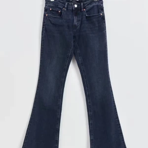 Mörkblå bootcut jeans - Snygga mörkblå bootcut jeans med klassisk femficksdesign och knappgylf. Perfekta för en avslappnad stil med en touch av retro. Nypris 500 kr och använda 1 gång 