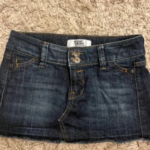 Lågmidjad jeanskjol - Snygg jeanskjol från Jeans Please i mörk denim med slitna detaljer.  Kjolen är kort och lågmidjad och stängs med två knappar. köptes på Plick för 500 säljer för 300😍😚