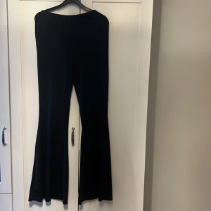 Svarta byxor från Shein - Snygga svarta byxor från Shein med en tight passform och utsvängda ben. Byxorna har en hög midja och är tillverkade i ett mjukt, stretchigt material som ger en bekväm känsla. Perfekta för en stilren look.