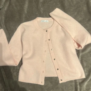 Ljusrosa kofta från Primark - Säljer en söt ljusrosa kofta från Primark. Den har långa ärmar och knäpps med stilrena fyrkantiga knappar. Perfekt för en mysig dag.