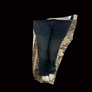 Blå bootcut jeans - Säljer ett par klassiska blå bootcut jeans med normal passform. De har en traditionell femficksdesign och är perfekta för en avslappnad stil. Passar bra till både sneakers och stövlar.