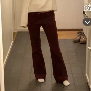 Vinröda byxor - Snygga röda manchesterbyxor med bootcut-stil. Perfekta för en trendig look med en skön passform. Kombinera med en stickad tröja för en avslappnad stil.