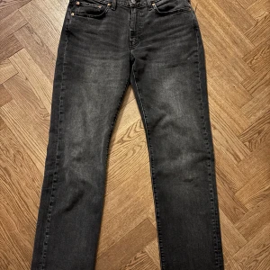 Levi's 514 - 32/32 - Snygga svartgrå Levi's 514 jeans med en klassisk straight passform. De har en midwaist design och är tillverkade i slitstarkt denim. Perfekta för en stilren look.