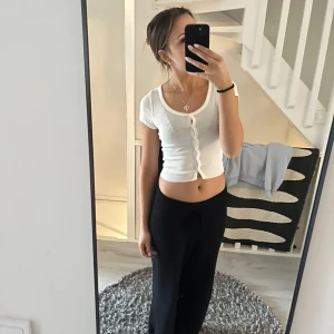 Vit ribbad kortärmad topp - Säljer en vit ribbad topp med korta ärmar och knappar framtill. Toppen är croppad och har en rund halsringning💕