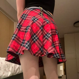 Rutig kjol  - Chic rutig kjol i rött och svart från Hampton Republic. Kjolen har en dragkedja baktill och ett elastiskt midjeband med ränder. Perfekt för en trendig look!