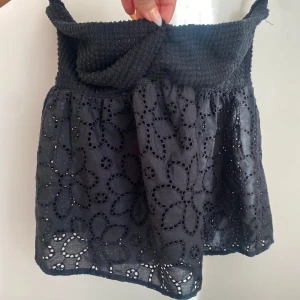 Axelbandslös topp  - Snygg svart axelbandslös topp med broderade blommor. Perfekt för sommaren!🌸🌸🌸. 