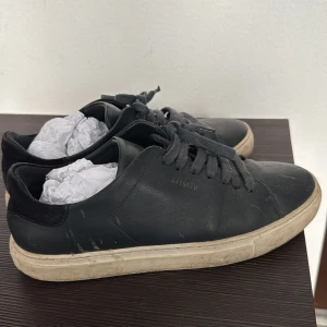 Mörk blåa sneakers från Axel Arigato - Snygga mörkblåa sneakers från Axel Arigato med snörning och vit sula. Skorna har en stilren design med en diskret logga på sidan. Perfekta för en casual look. Pris går att diskutera! Går att tvätta