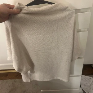 Beige tröja från Gina Tricot - Säljer en stilren beige tröja från Gina Tricot. Tröjan har en lös passform och är tillverkad i ett mjukt material. Perfekt för en avslappnad look. Utan armar