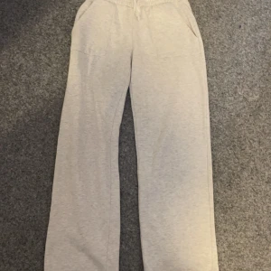 Gråa mjukisbyxor från 157 - Säljer ett par bekväma gråa mjukisbyxor från 157. Byxorna har en elastisk midja och raka ben, perfekta för en avslappnad stil. De har praktiska fickor både fram och bak.