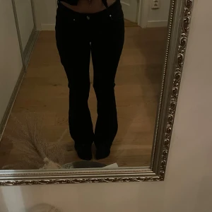 Gråa  low flare jeans - Snygga svarta low flare jeans med låg midja och knappdetaljer. Storlek S och längd 31. Nästan helt oanvända. Väldigt bra skick och snygga.