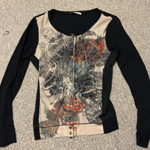 Mönstrad tröja med knappar - Snygg kofta med ett unikt mönster i flera färger. Den har långa ärmar och knappar framtill. Perfekt för att ge din outfit en färgglad touch.