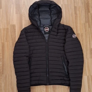 Svart pufferjacka från Colmar - Säljer en svart pufferjacka från Colmar med huva. Dragkedjans handtag är åkt av därav priset. Själva Dragkedjan funkar utmärkt! Resten av jackan är i mycket bra skick, skriv om ni har några övriga frågor! Den är för liten för mig på bilden, passar s-m