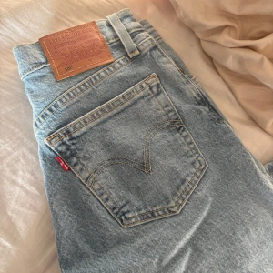 Levis 501 ljusblå jeans - Snygga Levis 501 jeans i en klassisk ljusblå färg. Dessa jeans har en ikonisk design med fem fickor och en bekväm passform. Perfekta för en avslappnad stil.