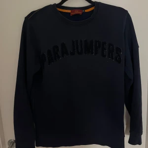 Mörkblå tröja från Parajumpers - Säljer en snygg mörkblå tröja från Parajumpers med deras logga i svart på bröstet. Tröjan sälj då den har blivit för liten annars hade ja gärna t haft kvar den, Tröjan har långa ärmar och en rund halsringning. Perfekt för en stilren och avslappnad look. Priset går att diskutera 