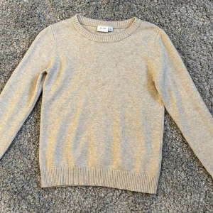 Beige stickad tröja från VILA - Säljer en stilren beige stickad tröja från VILA. Knappt använd 