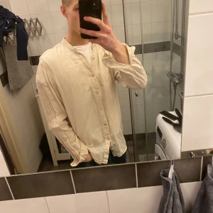 Beige långärmad skjorta - Säljer en stilren beige långärmad skjorta med knappar. Perfekt för en avslappnad look. Skjortan har en klassisk design och är lätt att matcha med olika outfits. Skjorta från pull & bear