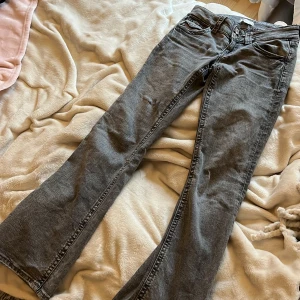 Grå jeans från Gina Tricot bootcut - Snygga grå jeans från Gina Tricot med en klassisk femficksdesign. Byxorna har en bootcut passform och är tillverkade i ett bekvämt denimtyg. Perfekta för en avslappnad stil.