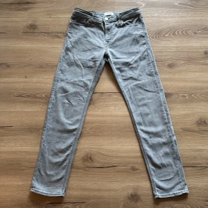 Grå jeans från Jack & Jones - Snygga grå jeans från Jack & Jones i modellen Tapered Mike. De har en klassisk femficksdesign och en bekväm passform. Perfekta för en avslappnad stil.
