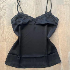 Svart linne med spets  - Super fint svart linne med spetsdetaljer i siden material. Använt ett fåtal gånger så är i mycket bra skick🫶
