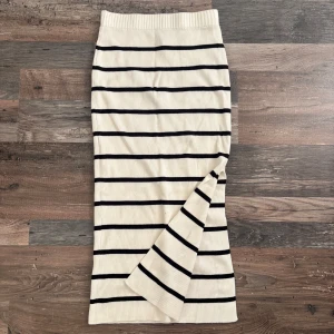 Randig kjol från Divided - Snygg randig kjol från Divided i svart och vit. Kjolen är ribbad och har en slits