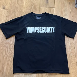 Vampsecurity t-shirt av Playboy carti  - Snygg svart t-shirt med texten 'Vampsecurity' i vitt på framsidan. Perfekt för en avslappnad stil. T-shirten har en normal passform och korta ärmar.