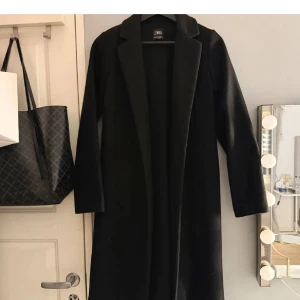 Svart kappa från Zara -  svart kappa från zara, bilderna är lånade!! Säljer då den inte används, den är cirka 97 cm lång, inget band tycärr!