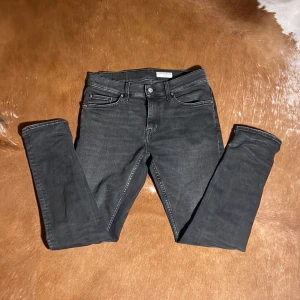 Tiger of Sweden Jeans - Jeans från Tiger of Sweden med slim passform. Jeans är mörkgråa med skön stilren tvätt. Jeansen är i storlek 30W 32L och passar modellen som är 185 och väger 65kg.