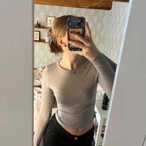 Grå långärmad topp från H&M Divided - Säljer en stilren grå långärmad topp från H&M Divided. Toppen har en tight passform. Använd 1 gång. 