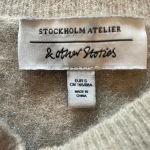 Beige tröja från & Other Stories - Säljer en mysig beige tröja från & Other Stories. Tröjan har trekvartsärmar och en rund halsringning. Perfekt för en avslappnad stil. 🧶