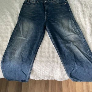 Blå jeansbyxor från weekday - Säljer ett par blå Galaxy jeansbyxor från Weekday, med en loose passform. Byxorna har en klassisk femficksdesign och är högmidjade. Perfekta för en avslappnad stil. Nästan helt nya. Har aldrig använd de därför att de sitter för stort på mig. 