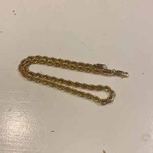 Cordell halsband med tvinnad design - Elegant guldhalsband med en tvinnad design som ger en stilren och klassisk look. Perfekt för att lägga till en touch av lyx till din outfit. Armbandet har en säker låsning. Kontakta vid frågor.