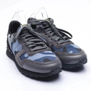 Rockrunners - Snygga sneakers från Valentino i grått och blått med ett coolt kamouflagemönster. Skorna har snörning och en robust sula för extra komfort. Perfekta för en stilren och avslappnad look. Kom privat för mer bilder eller frågor!