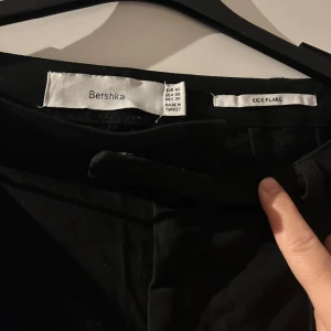 Svarta kick flare byxor från Bershka - Säljer ett par svarta kick flare byxor från Bershka i storlek M. De är i bra skick och perfekta för både vardag och fest. Byxorna har en stilren design med hög midja och en lätt utsvängd passform vid anklarna. Tillverkade i ett bekvämt material som ger en snygg siluett. Passar perfekt till både sneakers och klackar!