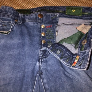 Tramarossa Jeans, Leonardo strl 31 - Säljer ett par super schyssta jeans i det kvalitativa italienska märket Tramarossa. Strl 31 i modellen Leonardo. 6% cashmire och 93% bomull. Skicket är väldigt bra förutom att det är ett hål i vänster ficka. Hålet skulle defenitivt lätt gå och fixa och gör inte så saker ramlar ur. Skriva gärna ett meddelanden vid funderingar eller fler bilder.👌