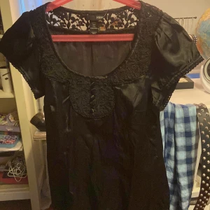 Svart t-shirt från H&M - Snygg svart t-shirt i storlek 36. Den har korta ärmar och vacker spetsdetalj vid halsringningen och axlarna. Glansigt material💕