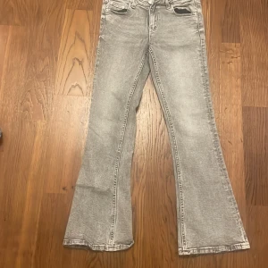 Grå bootcut jeans från Gina Tricot - Säljer ett par snygga grå bootcut jeans från Gina Tricot i storlek 146. De har en klassisk femficksdesign och en bekväm passform. Perfekta för både vardag och fest! 🖤