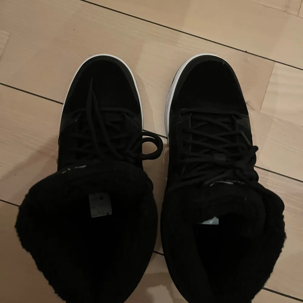 Höga sneakers från Puma. Sneakers Rebound Layup Fur SD JR från Puma i mocka med detaljer i syntet och varmfodrade med mjuk fuskpäls. Plös och skaft är bekvämt vadderade.  Funktion: Varmfodrat Innersula: Pälsimitation Ovandel: Skinn/syntet Yttersula: Gummi. Skor.