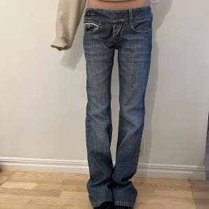 Säljer ett par snygga blå jeans med bootcut. De har en låg midja och klassisk femficksdesign med knappar och dragkedja. De är lite långa för mig som är 168 och de är lite stora i midjan, jag har vanligtvis 35 rakt över.