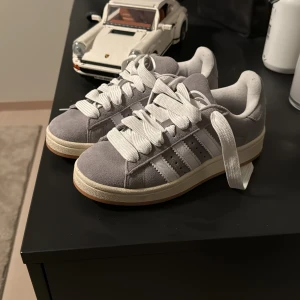 Grå Adidas sneakers - Säljer ett par helt oanvända snygga grå Adidas sneakers i mocka. Adidas campus