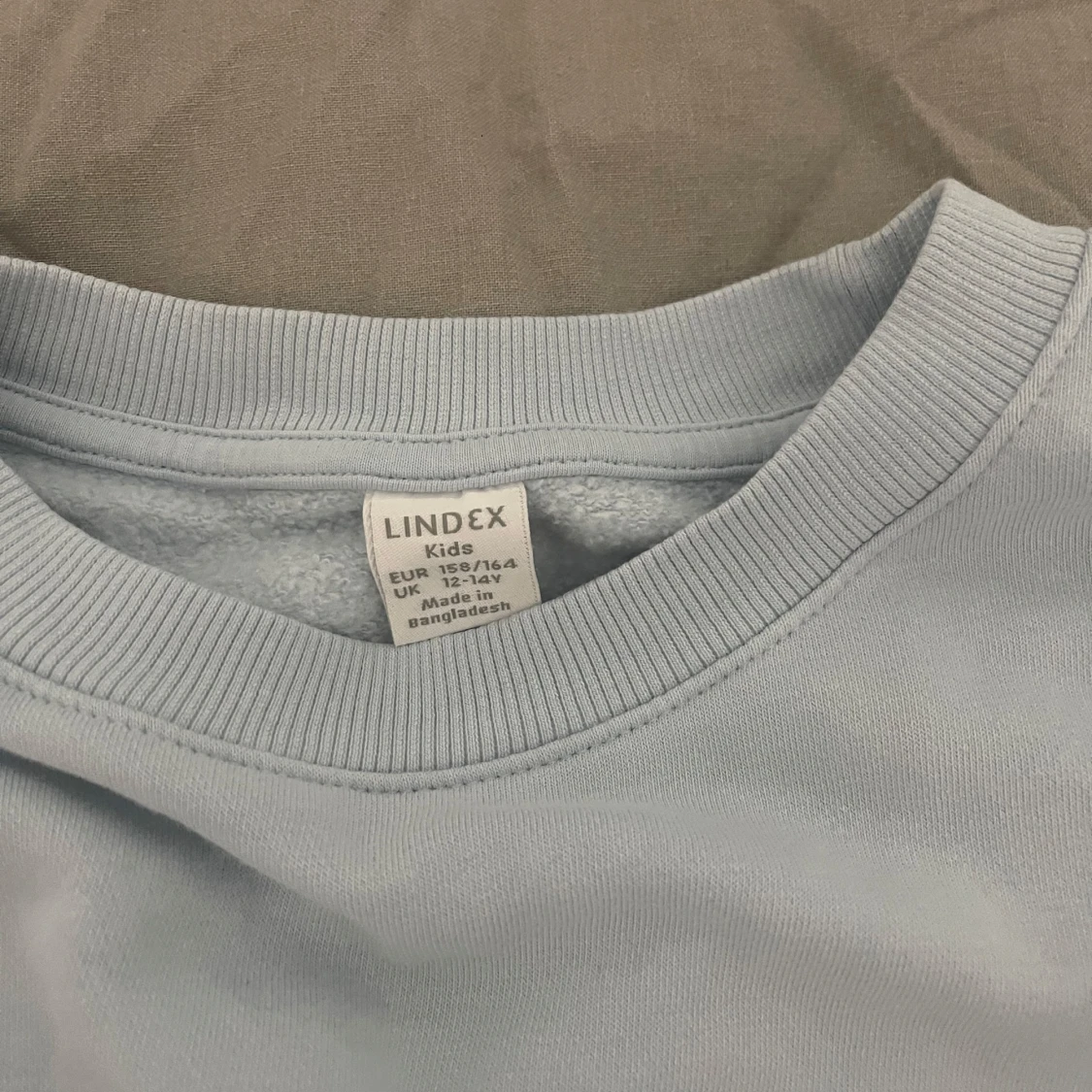 Ljusblå tröja med volanger på ärmarna från Lindex  - 91