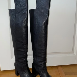 Svarta höga stövlar i skinn - Säljer ett par svarta höga stövlar i skinn med klack. De är i mycket bra skick och perfekta för höst och vinter. Stövlarna har en stilren design med spetsig tå och är gjorda för att hålla värmen. Perfekta för både vardag och fest!