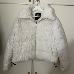 Vit teddyjacka  - Superfin vit teddyjacka från FB Sister i storlek L. Jackan är fluffig och varm, perfekt för kyliga dagar. Den har en dragkedja framtill och långa ärmar. Passar perfekt till både vardag och festliga tillfällen. Jag är i storlek S i vanliga fall och L passade perfekt, då den är liten i storleken. Finns en liten sminkfläck på tredjebilden men den syns knappast!!