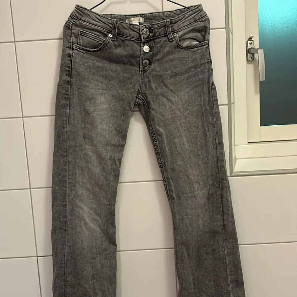 Säljer ett par grå jeans från Gina Tricot i storlek 152. De har en klassisk femficksdesign och knappar framtill. Perfekta för vardagsbruk med en bekväm passform. Passar bra till både t-shirt och tröja. Hör av dig vid intresse!. Jeans & Byxor.