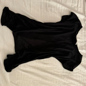 Svart topp från Atmosphere - Snygg svart topp från Atmosphere i storlek 34. Perfekt för en kväll ute eller en fest. Toppen har en enkel och elegant design som passar till många tillfällen. Den är tillverkad i ett mjukt material som känns skönt mot huden! Den är dessutom öppen i ryggen💗 köpt för 450 