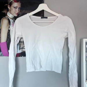 Vit långärmad topp från Brandy Melville - Säljer en superfin vit långärmad topp från Brandy Melville. Den är croppad och har en rund halsringning. Perfekt för både vardag och fest! Toppen är i bra skick och väldigt bekväm att ha på sig.
