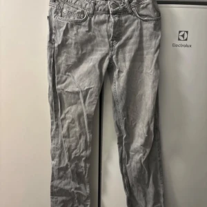 Grå jeans från 157 - Säljer ett par grå jeans från märket 157. De har en klassisk design med fem fickor och knappgylf. Perfekta för vardagsbruk och kan matchas med det mesta i garderoben. Passformen verkar vara normal och de ser ut att vara i bra skick.