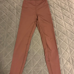 Rosa leggings från Casall - Säljer ett par snygga rosa leggings från Casall i storlek S. De är högmidjade och perfekta för träning eller en avslappnad dag. Materialet är mjukt och stretchigt, vilket ger en bekväm passform. Perfekta för både gymmet och vardagsbruk!