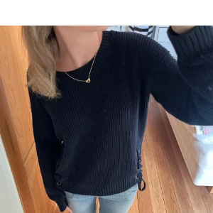 Blå stickad tröja med snörning - Säljer en snygg blå stickad tröja med snygg snörning på sidorna. Perfekt för höst och vinter, den är både varm och stilren. Tröjan har långa ärmar och en normal passform. Passar perfekt till jeans för en avslappnad look. Bilderna är lånade, kontakta för mer info🥰