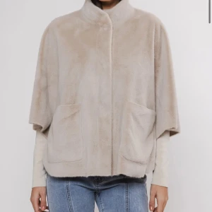 Beige pälsjacka från Rino & Pelle - Säljer en supermjuk och stilren beige pälsjacka från Rino & Pelle. Jackan har en lös passform med stora fickor framtill och en hög krage. Perfekt för höst och vinter när du vill hålla dig varm och snygg. Passar både till vardags och fest! 🧥✨